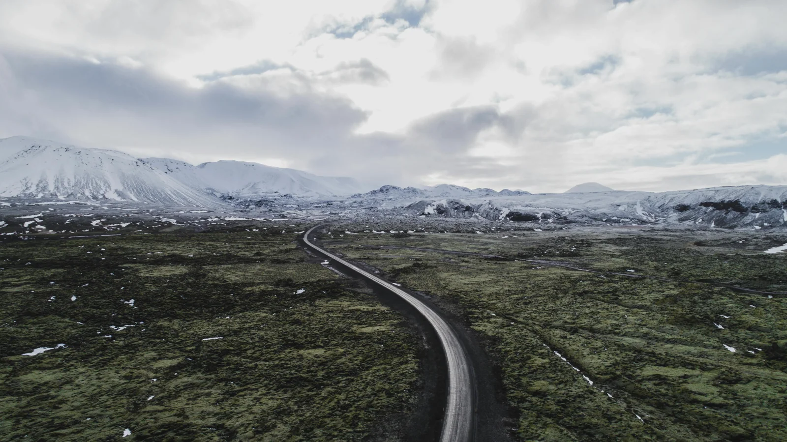 一条公路穿过苔原，向远处的雪山延伸